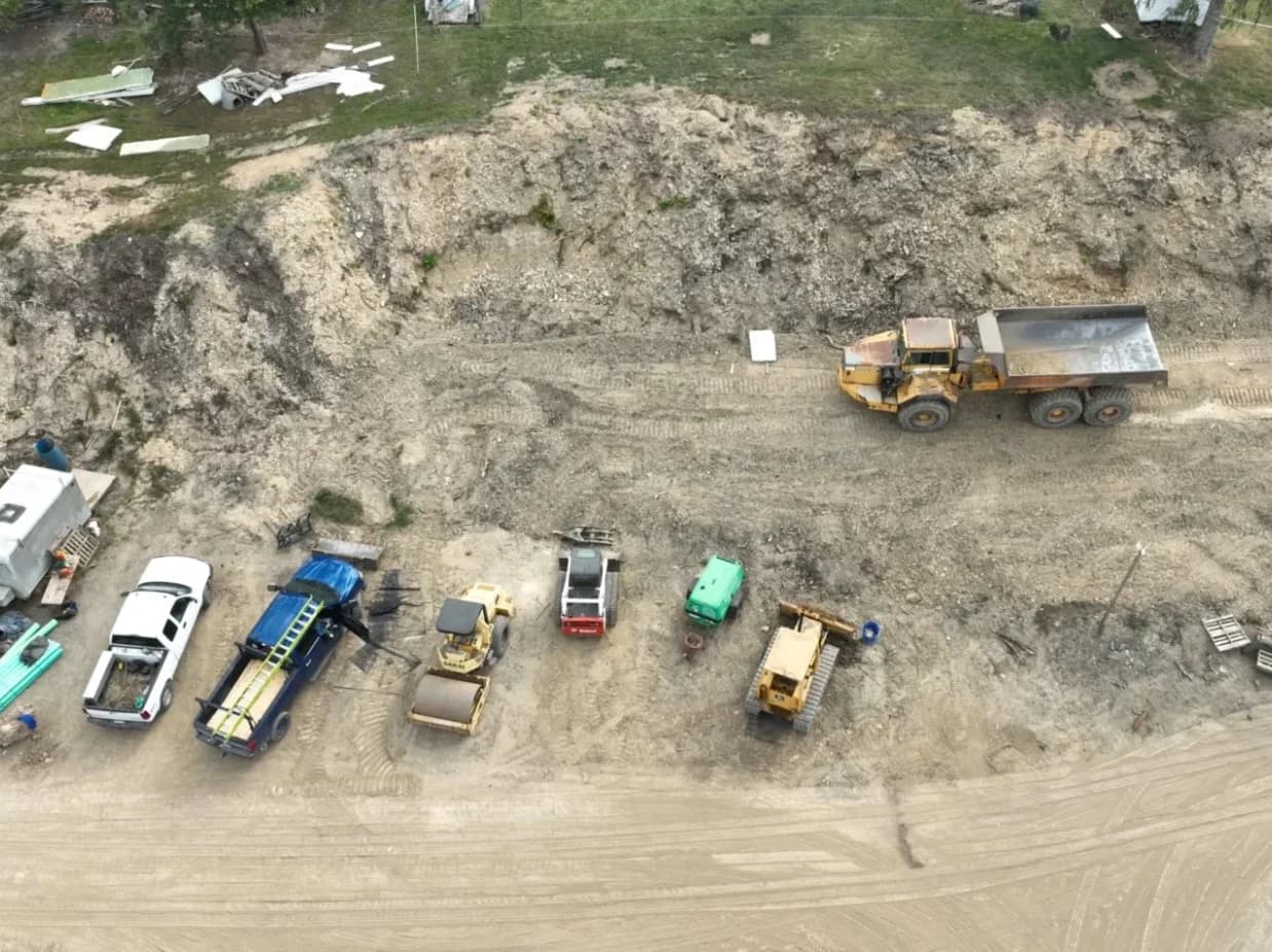 Triple Crown fleet on a graded site — articulated dump truck, roller, and dozer