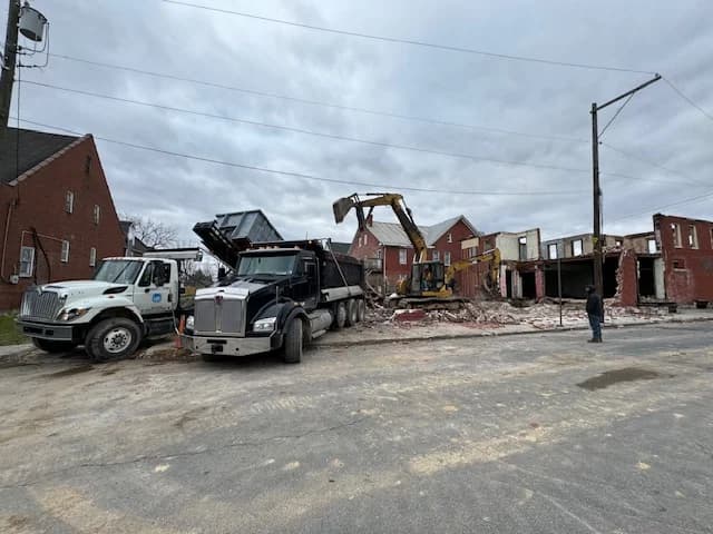 Triple Crown dump trucks at a job site during a building demolition